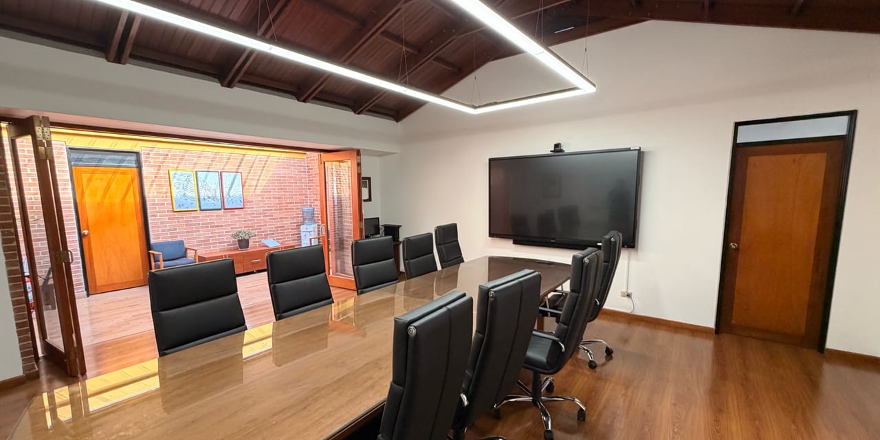 Sala de juntas con pantalla interactiva y cámara de videoconferencia