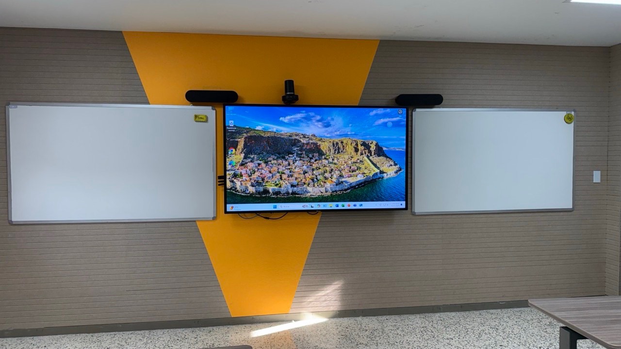 Pantalla interactiva con cámara y dos barras de sonido en un aula de la Universidad Simón Bolívar